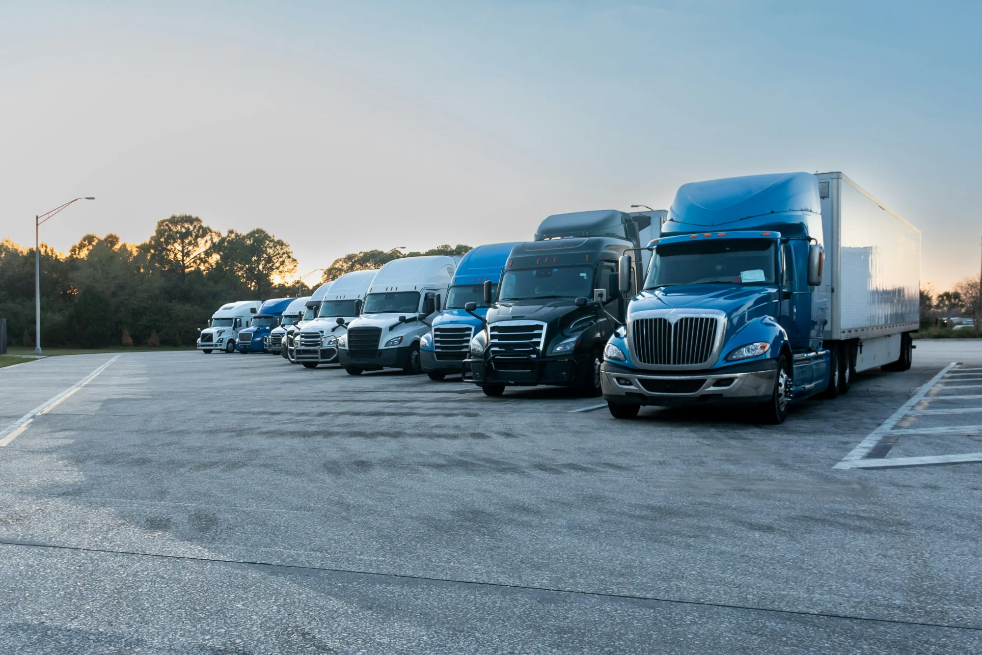 Commercial semi trucks parked safely inside a private truck parking yard.
